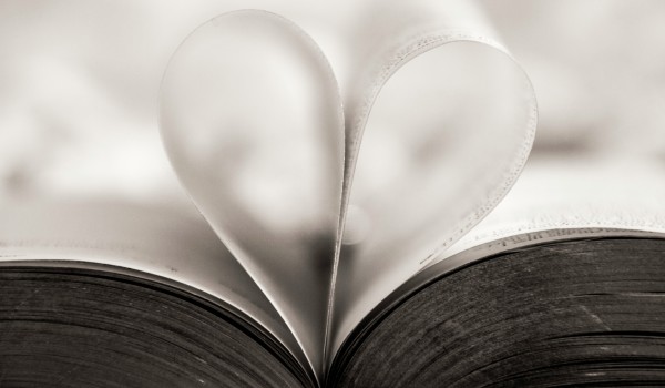 Two pages of a book curl together to form a heart shape