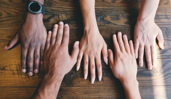 Hands of five persons connected together